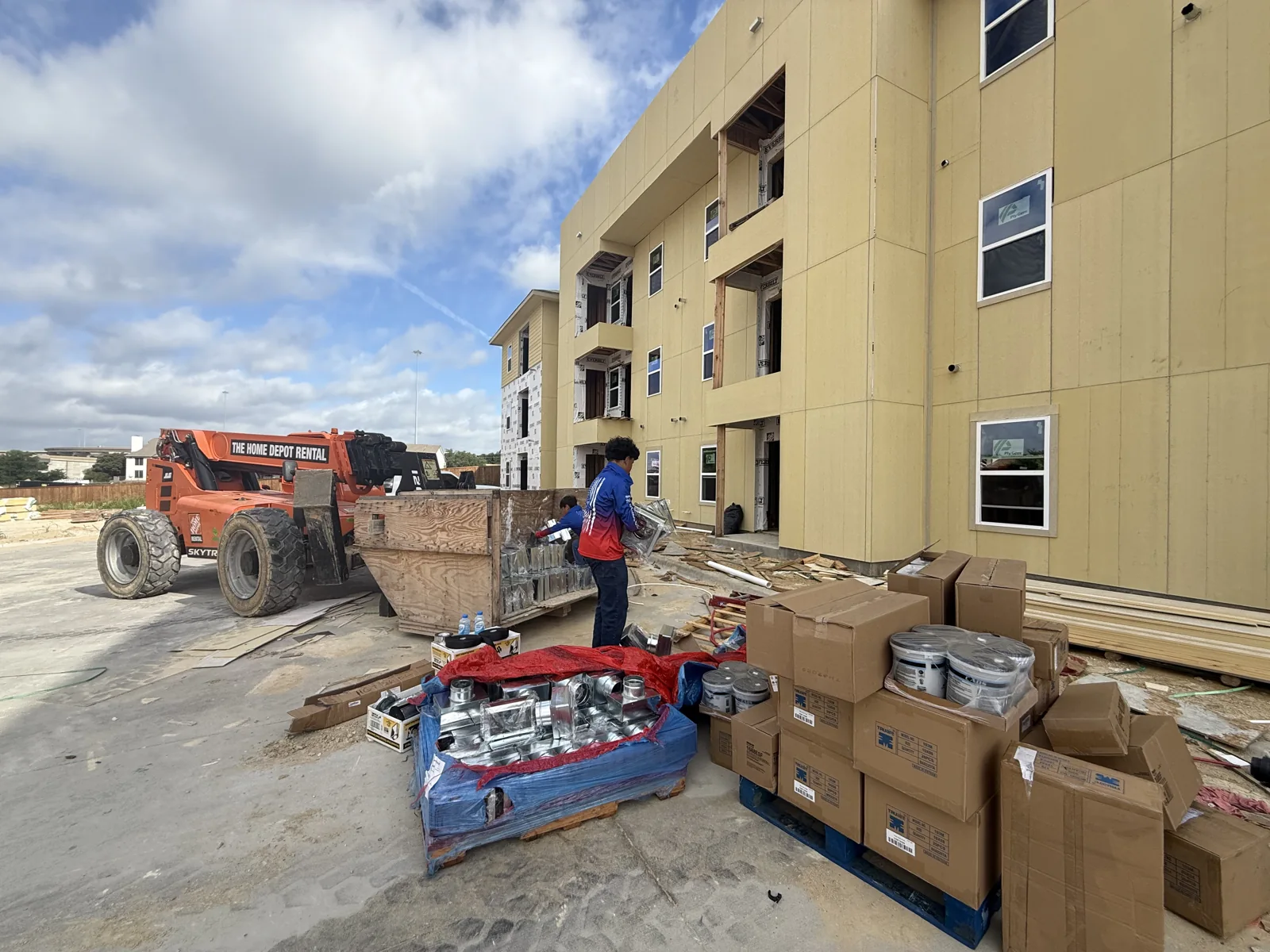 Roma technician beside boxed equipment at a construction site