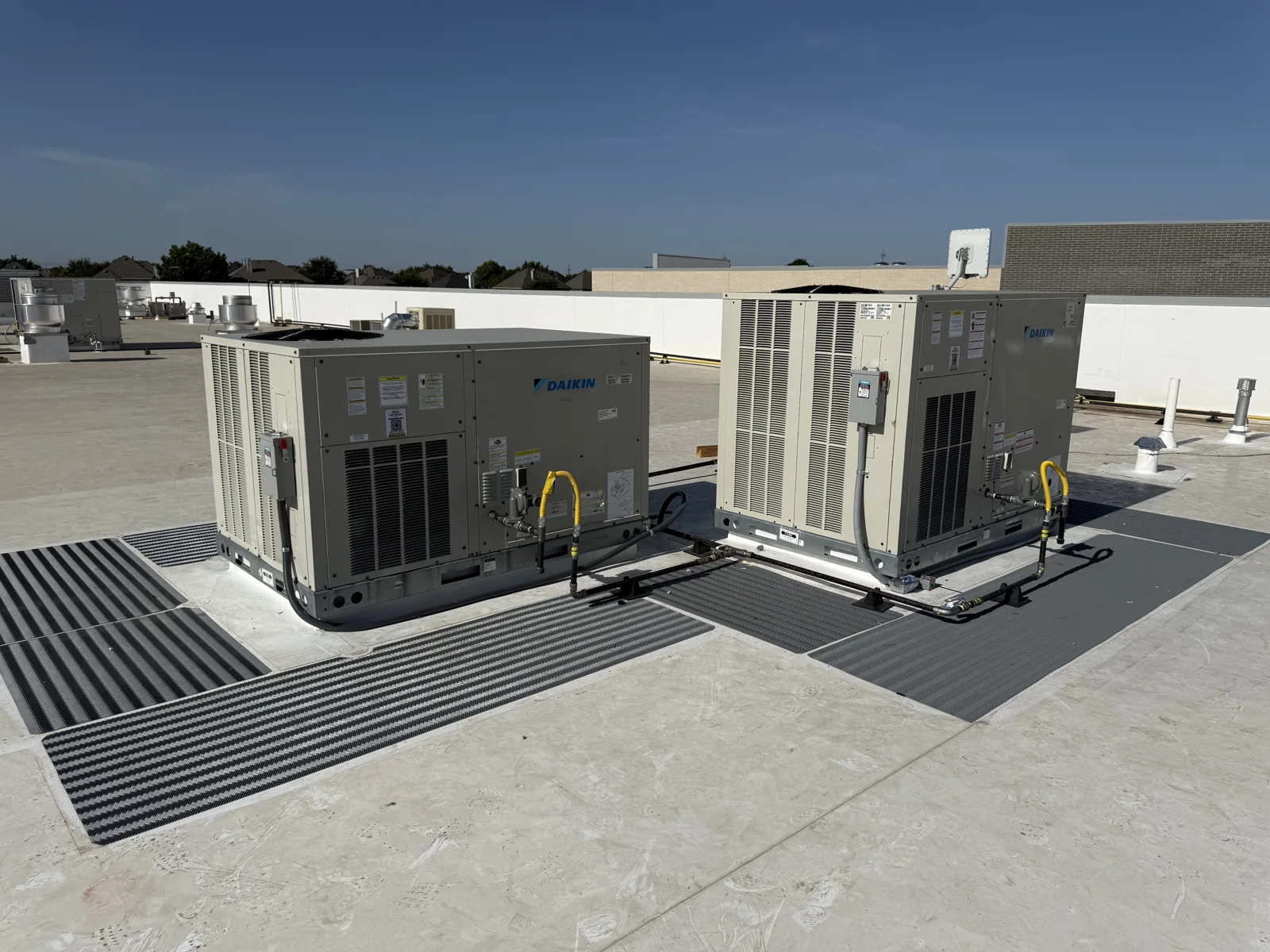 Two packaged rooftop HVAC units with connected piping